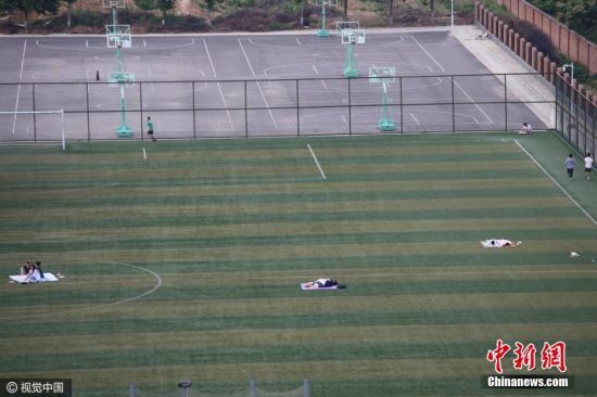 西安持续高温 大学生夜睡足球场