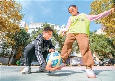 在河南省洛阳市涧西区一小区广场,足球教练梁浩杰正在开展上门教学服务。张怡熙摄(人民图片)