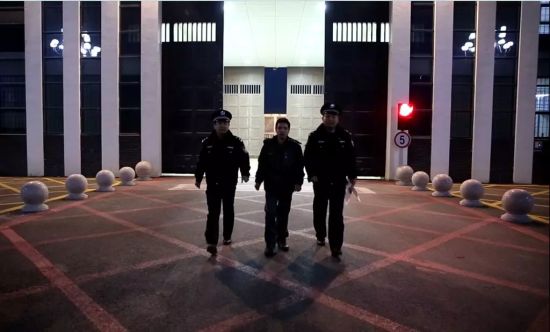 胡小杰在监区民警的带领下走出监狱大门