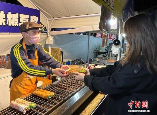 10月21日晚,山东烟台,食客在购买台湾小吃。陈宇婷 摄 10月21日晚,山东烟台,食客在购买台湾小吃。陈宇婷 摄