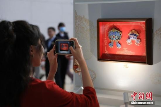 资料图:游客手持“珐琅镶玉葫芦”文创产品与河南博物院馆藏文物对比。 中新社记者 范晓恒 摄 资料图:游客手持“珐琅镶玉葫芦”文创产品与河南博物院馆藏文物对比。 中新社记者 范晓恒 摄