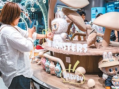 近日,在上海一家泡泡玛特门店,展柜上的玩偶吸引消费者驻足拍摄。 王 初摄(人民视觉) 近日,在上海一家泡泡玛特门店,展柜上的玩偶吸引消费者驻足拍摄。 王 初摄(人民视觉)