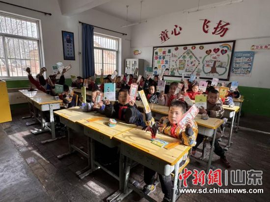 山区留守儿童展示获赠图书等物资。学院供图 山区留守儿童展示获赠图书等物资。学院供图