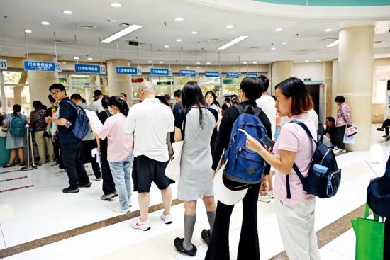 2025年6月4日,陪诊师张晴(右一)排队为客户办理医保联网。图/IC 2025年6月4日,陪诊师张晴(右一)排队为客户办理医保联网。图/IC